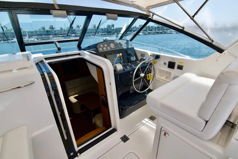 Revelry Yacht Photos Pics 2002 Tiara Yachts 3500 Open cockpit with steering wheel and cabin entrance.