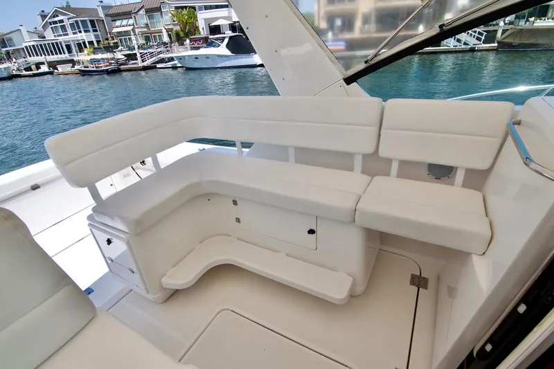 Revelry Yacht Photos Pics 2002 Tiara Yachts 3500 Open interior with white seating, docked near waterfront homes.