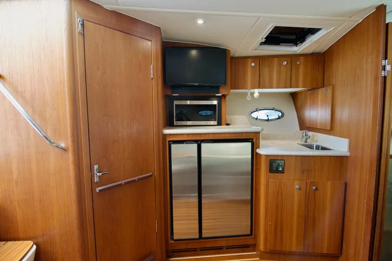 Revelry Yacht Photos Pics 2002 Tiara Yachts 3500 Open interior with kitchenette, wood cabinetry, and modern appliances.