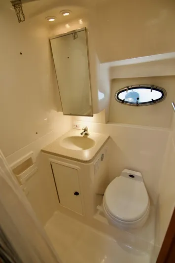 Revelry Yacht Photos Pics 2002 Tiara Yachts 3500 Open bathroom with sink, toilet, and porthole window.