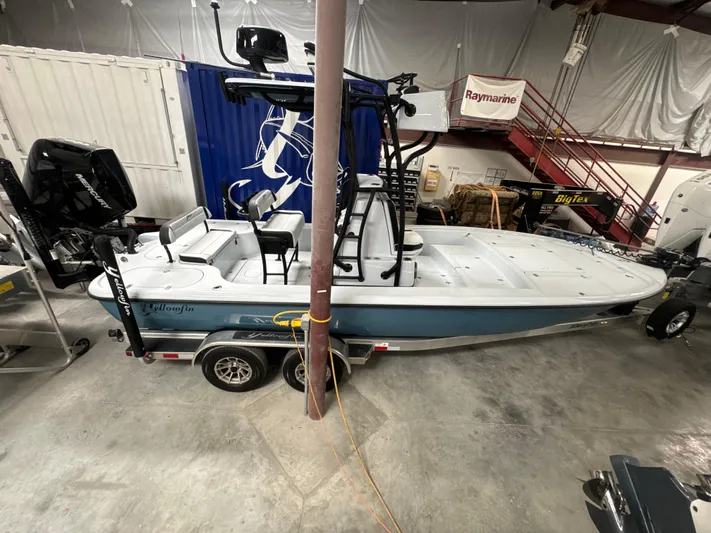  Yacht Photos Pics 2025 Yellowfin 24 CE boat in a garage, featuring a sleek design and dual engines.