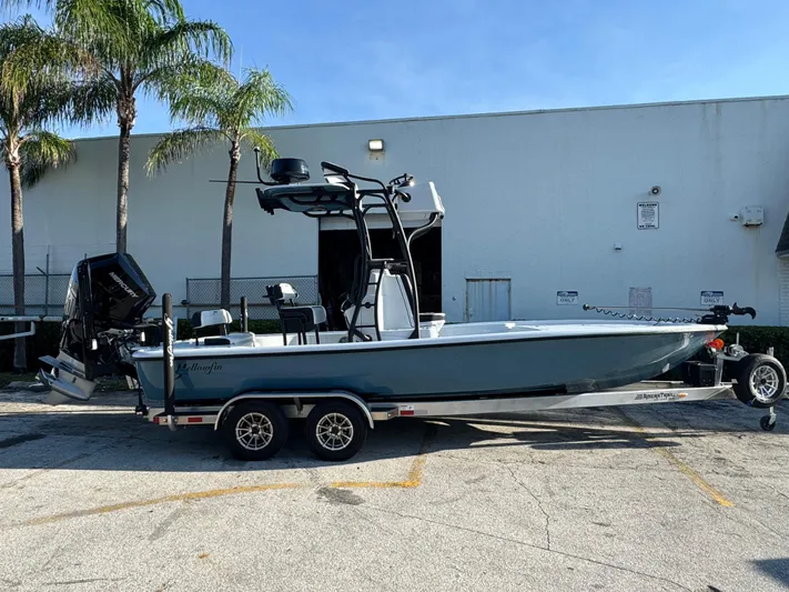  Yacht Photos Pics 2025 Yellowfin 24 CE boat on trailer, parked outdoors near palm trees.