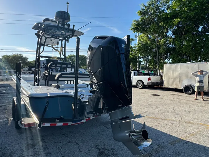  Yacht Photos Pics 2025 Yellowfin 24 CE boat with powerful outboard motor, parked outdoors on a sunny day.