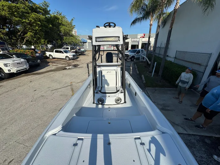  Yacht Photos Pics 2025 Yellowfin 24 CE boat in a parking lot, surrounded by trees and vehicles.