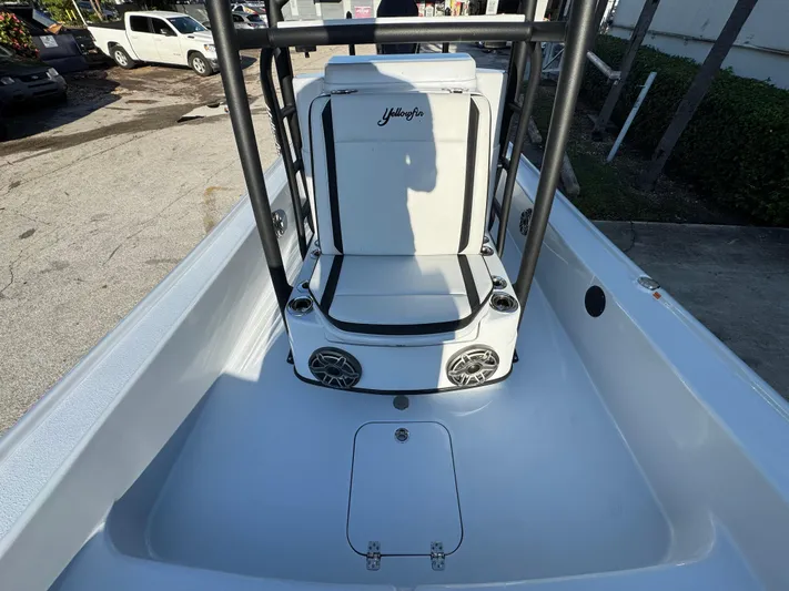  Yacht Photos Pics 2025 Yellowfin 24 CE boat interior with seating and speakers, parked outdoors.