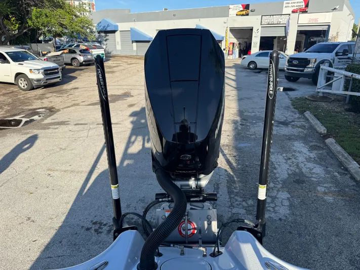  Yacht Photos Pics 2025 Yellowfin 24 CE boat engine with Power-Pole anchors in a parking lot.