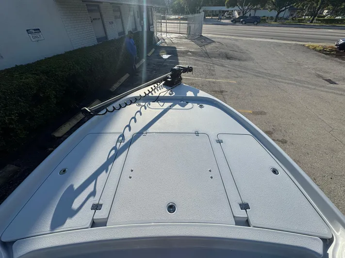  Yacht Photos Pics 2025 Yellowfin 24 CE boat deck with trolling motor, parked in a lot.