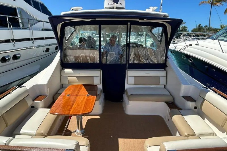  Yacht Photos Pics 2012 Tiara Yachts 3100 Coronet interior with seating and wooden table, docked at marina.