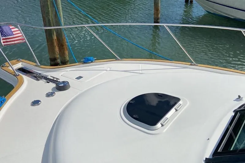  Yacht Photos Pics 2012 Tiara Yachts 3100 Coronet bow with American flag, docked on calm water.