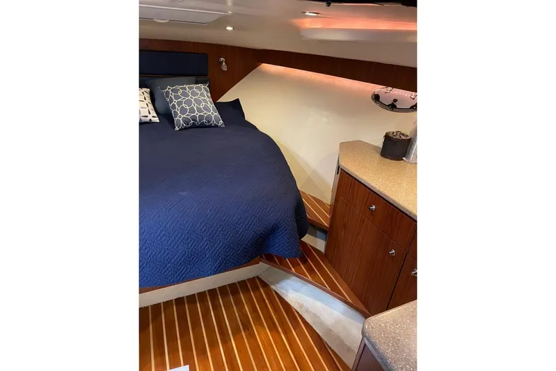  Yacht Photos Pics 2012 Tiara Yachts 3100 Coronet cabin with blue bedding and wooden cabinetry.
