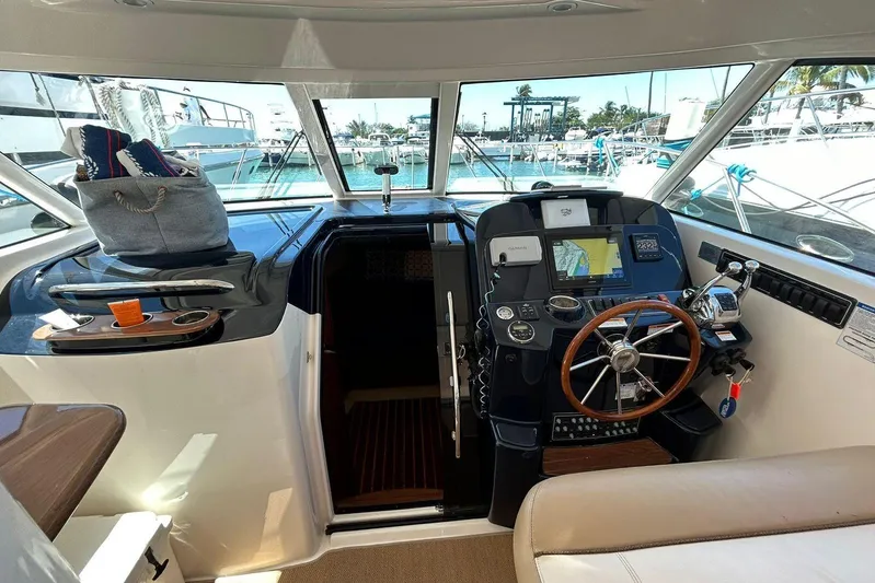  Yacht Photos Pics 2012 Tiara Yachts 3100 Coronet helm with navigation equipment and wooden steering wheel.