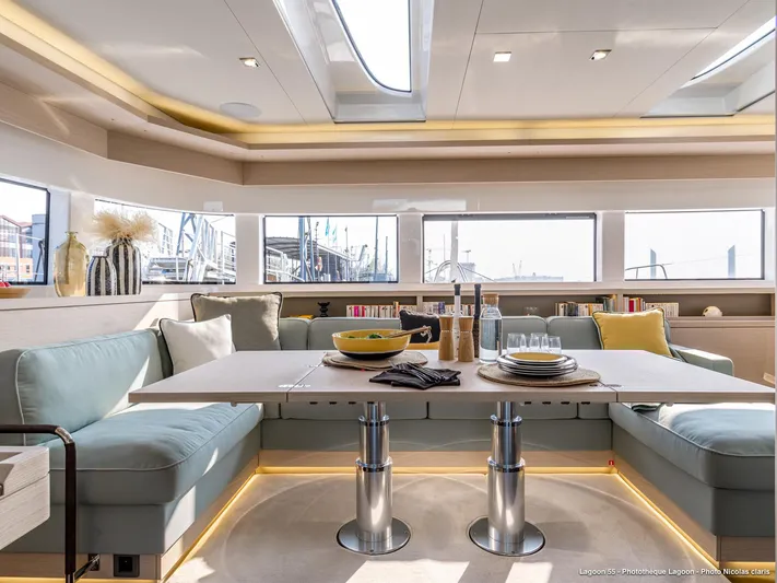  Yacht Photos Pics Luxurious interior of 2024 Lagoon 55 yacht with elegant dining area and panoramic windows.
