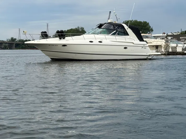  Yacht Photos Pics 2000 Cruisers Yachts 3870 Express boat docked on calm water.