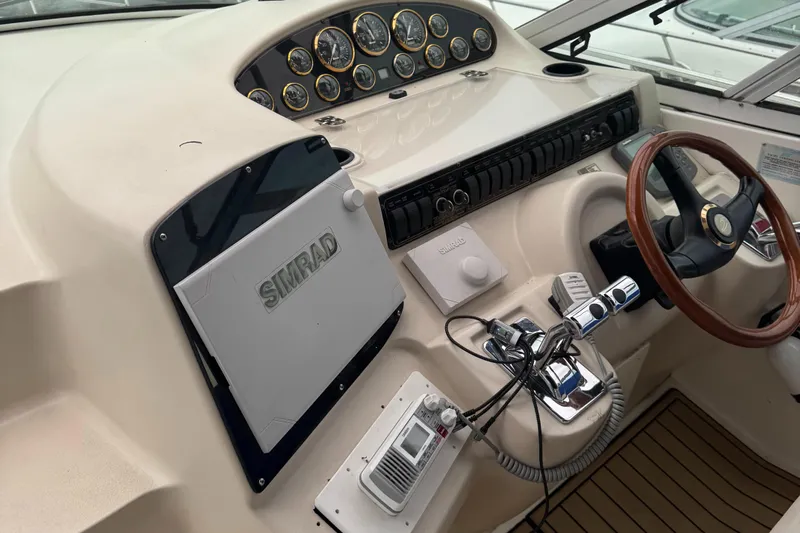  Yacht Photos Pics 2000 Cruisers Yachts 3870 Express helm with Simrad navigation and wood steering wheel.
