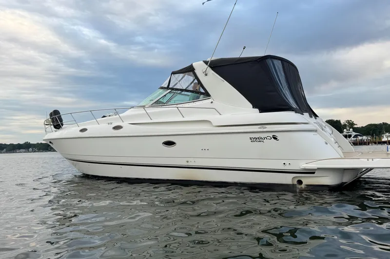  Yacht Photos Pics 2000 Cruisers Yachts 3870 Express on calm water under cloudy sky.
