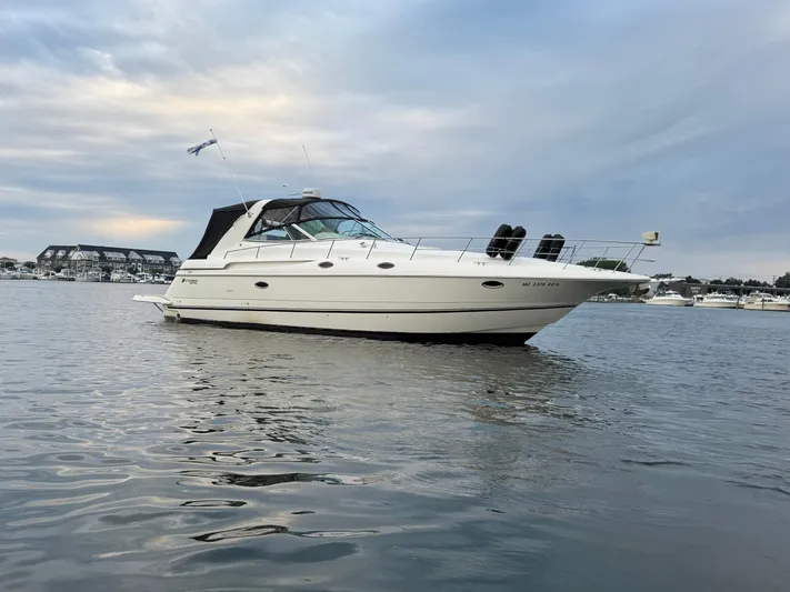  Yacht Photos Pics 2000 Cruisers Yachts 3870 Express on calm water under cloudy sky.