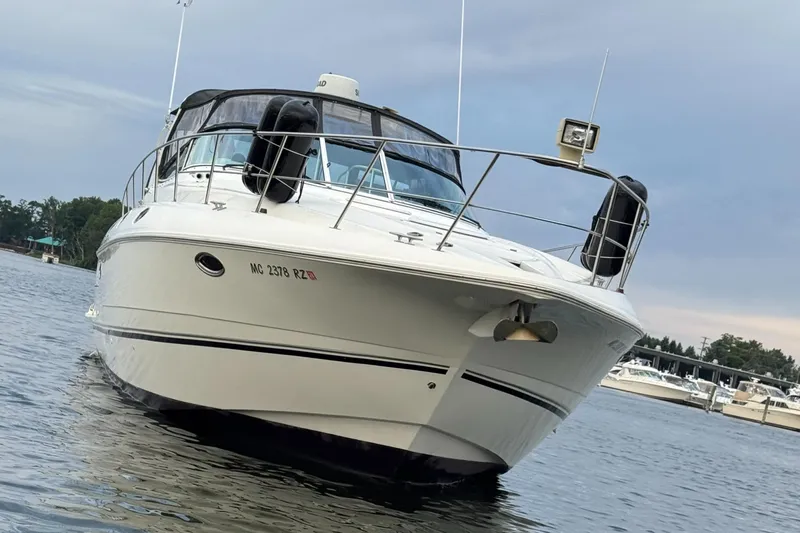  Yacht Photos Pics 2000 Cruisers Yachts 3870 Express on water, front view, with marina background.