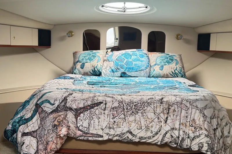  Yacht Photos Pics Luxurious cabin interior of 2000 Cruisers Yachts 3870 Express with nautical-themed bedding.