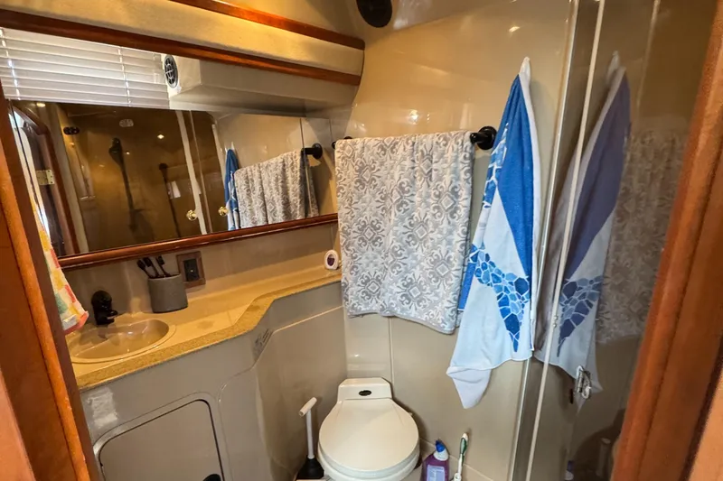  Yacht Photos Pics Bathroom interior of 2000 Cruisers Yachts 3870 Express with sink, mirror, and towels.