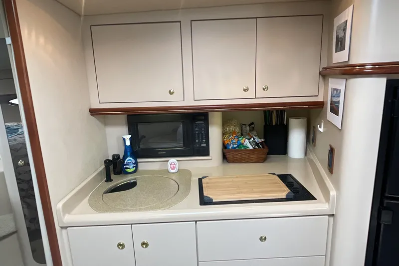  Yacht Photos Pics 2000 Cruisers Yachts 3870 Express galley with sink, microwave, and storage cabinets.