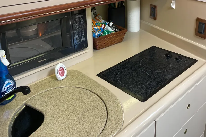  Yacht Photos Pics 2000 Cruisers Yachts 3870 Express kitchen with stove, microwave, and sink.