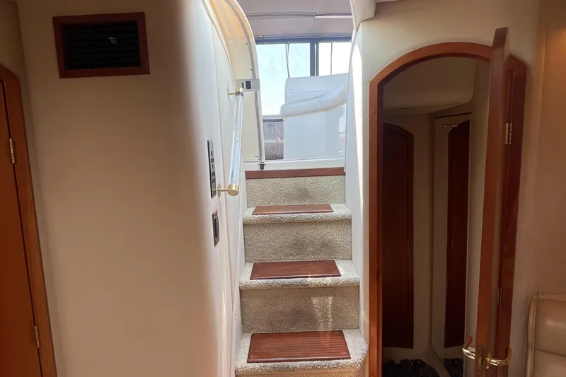  Yacht Photos Pics Interior stairs of 2000 Cruisers Yachts 3870 Express, featuring wood accents and carpeted steps.