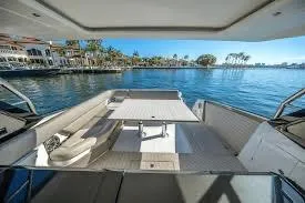 47 Verve Yacht Photos Pics 2021 Azimut Verve 47 yacht interior with seating and table, overlooking serene waterfront.