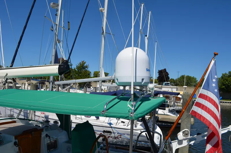 Fleur De Lys Yacht Photos Pics Sailboat docked at marina, featuring green canopy and American flag, Hans Christian Christina 1986.