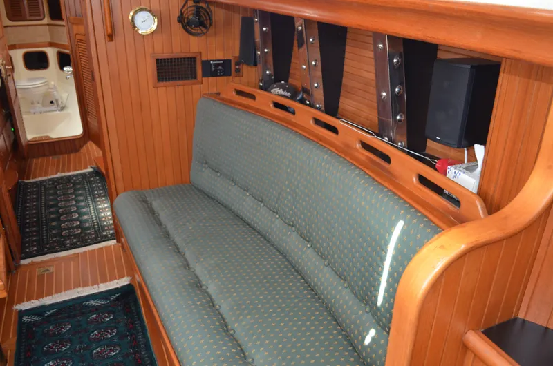 Fleur De Lys Yacht Photos Pics Interior of 1986 Hans Christian Christina yacht with wooden paneling and cushioned seating.