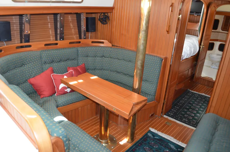 Fleur De Lys Yacht Photos Pics Interior of 1986 Hans Christian Christina yacht with wooden finish and cozy seating area.