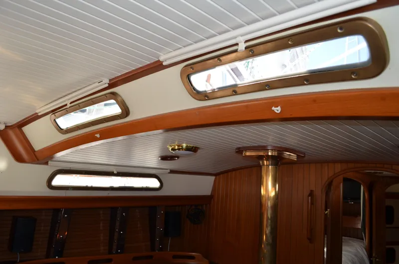 Fleur De Lys Yacht Photos Pics Interior of 1986 Hans Christian Christina sailboat with wooden accents and porthole windows.