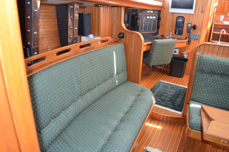 Fleur De Lys Yacht Photos Pics 1986 Hans Christian Christina yacht interior with green upholstery and wooden paneling.