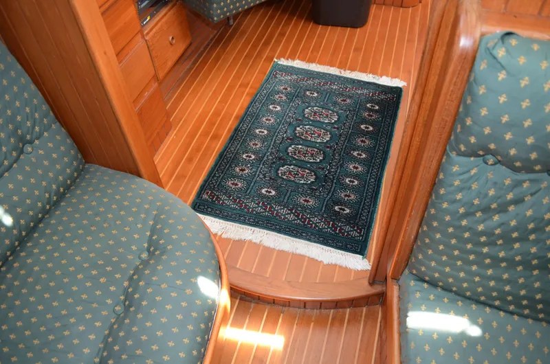 Fleur De Lys Yacht Photos Pics Interior of 1986 Hans Christian Christina yacht with patterned rug and cushioned seating.
