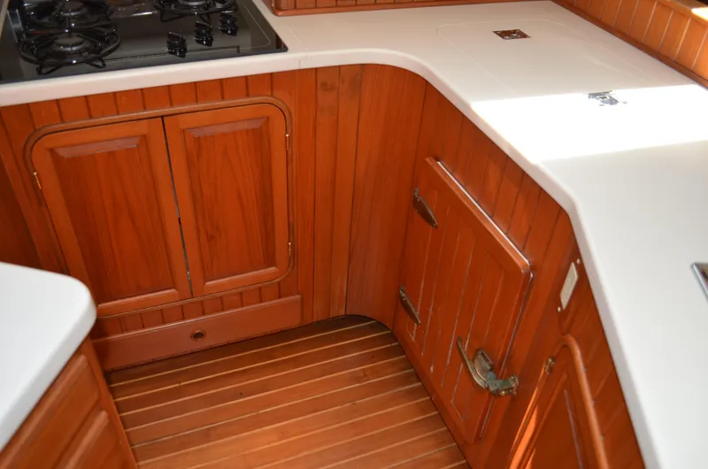 Fleur De Lys Yacht Photos Pics Wooden yacht kitchen interior with stove, cabinets, and white countertops, Hans Christian Christina 1986.