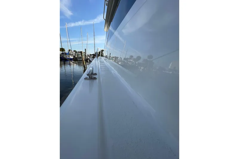  Yacht Photos Pics 2003 Egg Harbor 37 Sport Fisher boat docked, reflecting marina and sky.