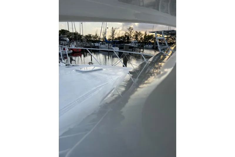  Yacht Photos Pics 2003 Egg Harbor 37 Sport Fisher at marina during sunset, reflecting on water.