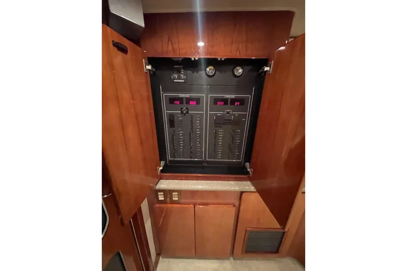  Yacht Photos Pics Electrical panel inside 2003 Egg Harbor 37 Sport Fisher yacht, with open wooden cabinet doors.