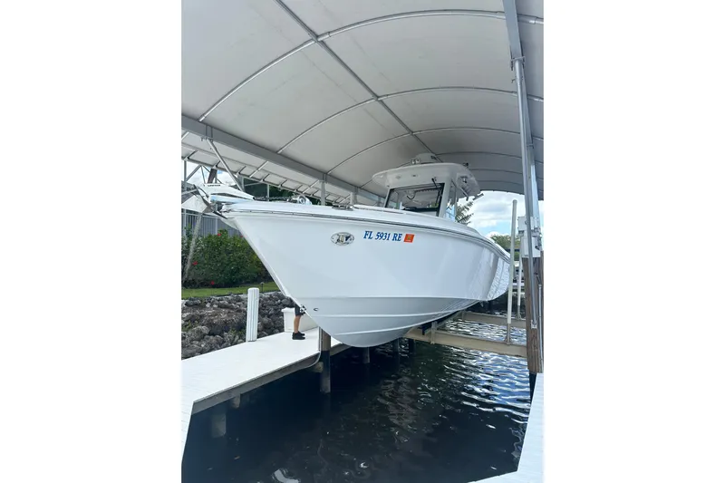  Yacht Photos Pics 2015 Everglades 295 Center Console boat docked under a canopy.