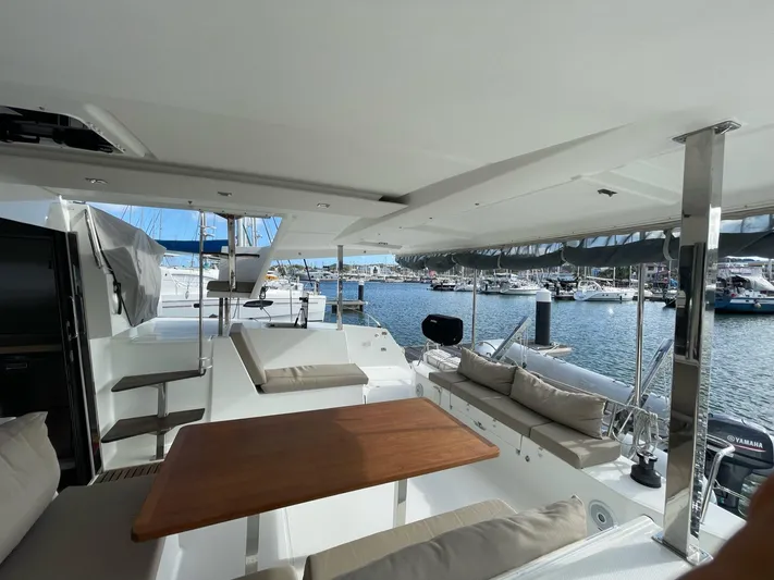  Yacht Photos Pics Spacious deck of 2019 Fountaine Pajot Lucia 40 catamaran, featuring comfortable seating and scenic marina view.