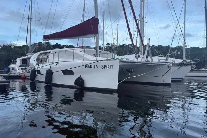 Manila Spirit Yacht Photos Pics Catamaran "Manila Spirit" docked, Dean 5000 model, 2012, with red sail cover.