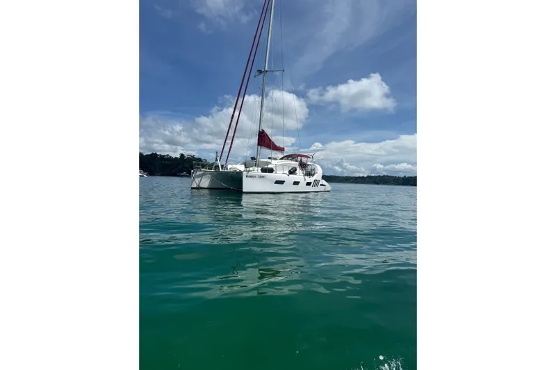 Manila Spirit Yacht Photos Pics Sailing catamaran Dean 5000 (2012) on calm waters under a clear blue sky.
