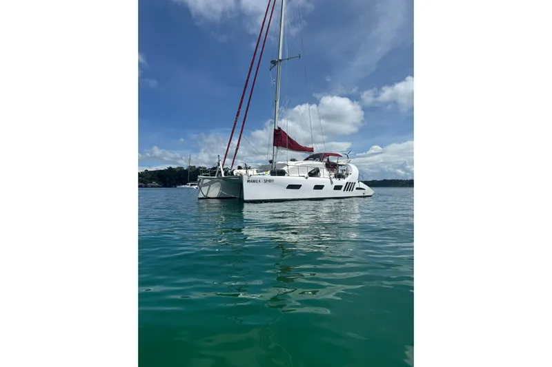 Manila Spirit Yacht Photos Pics Sailing catamaran Dean 5000, 2012 model, on calm waters under a clear blue sky.