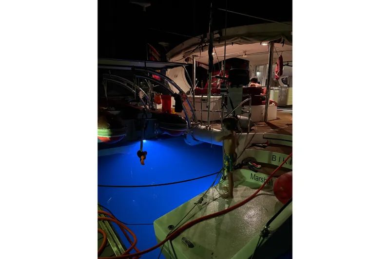 Manila Spirit Yacht Photos Pics Child on a 2012 Dean 5000 yacht at night, illuminated by blue underwater lights.