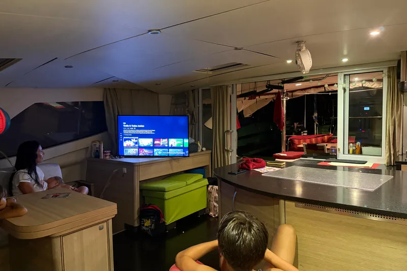 Manila Spirit Yacht Photos Pics Interior of a 2012 Dean 5000 yacht with people watching TV.