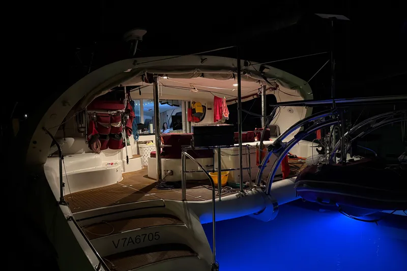 Manila Spirit Yacht Photos Pics Illuminated Dean 5000 yacht interior at night, showcasing cozy seating and vibrant blue underwater lights.