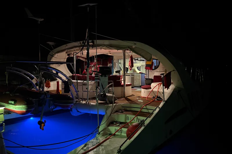 Manila Spirit Yacht Photos Pics Luxurious 2012 Dean 5000 yacht illuminated at night with vibrant blue underwater lights.