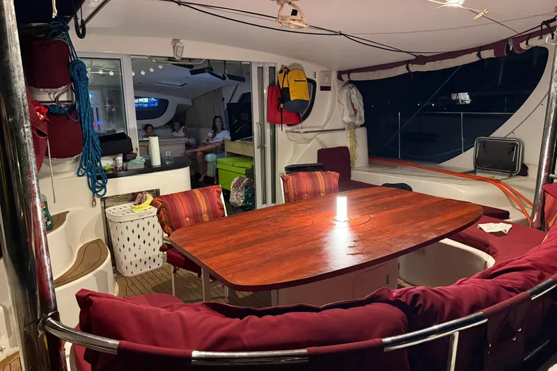 Manila Spirit Yacht Photos Pics Interior of 2012 Dean 5000 yacht with wooden table, red cushions, and cozy seating area.