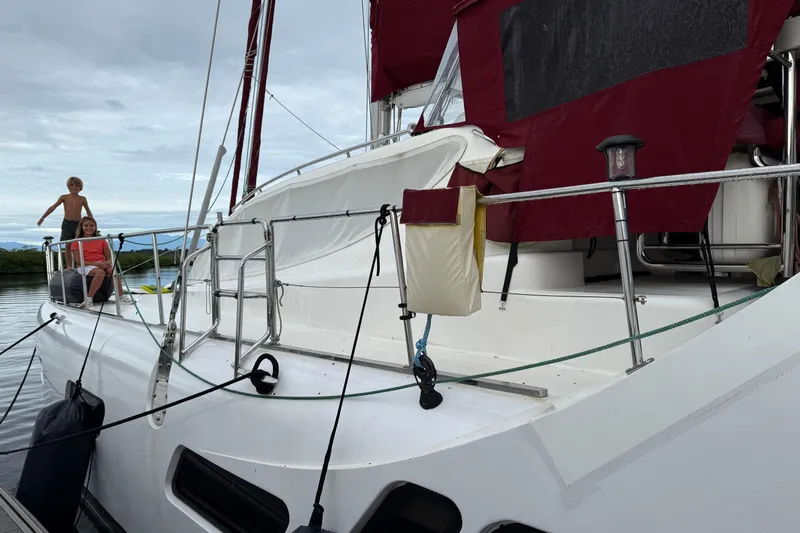 Manila Spirit Yacht Photos Pics Sailing yacht Dean 5000, 2012 model, with people on deck, docked by calm waters.