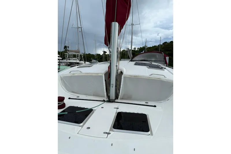 Manila Spirit Yacht Photos Pics Sailboat deck view, Dean 5000 model, 2012, with red sail and cloudy sky.