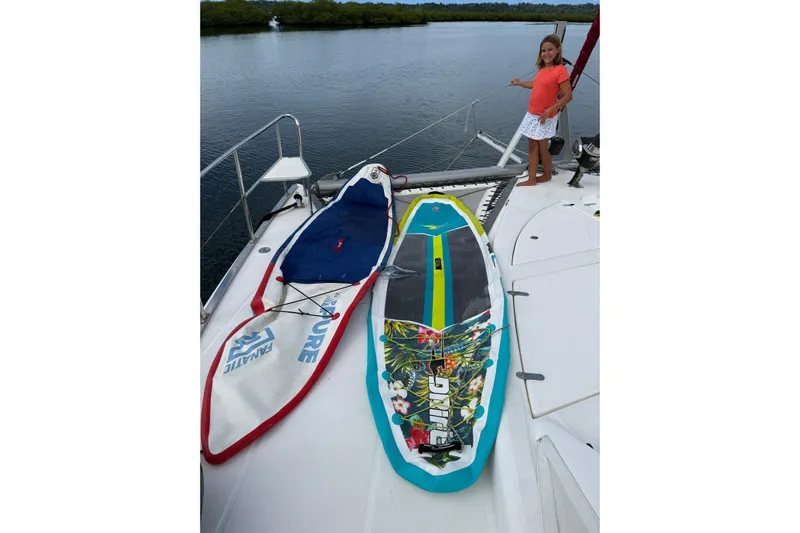 Manila Spirit Yacht Photos Pics Child on a Dean 5000 yacht with colorful surfboards, 2012 model, near calm water.